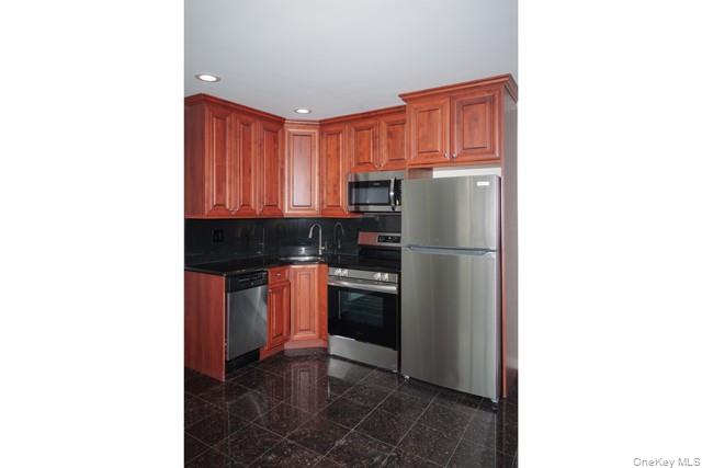 118 Carleton Avenue, Unit 6B Islip Terrace, NY 11752 - Photo 4 of 9 a kitchen with stainless steel appliances granite countertop a refrigerator and a stove top oven
