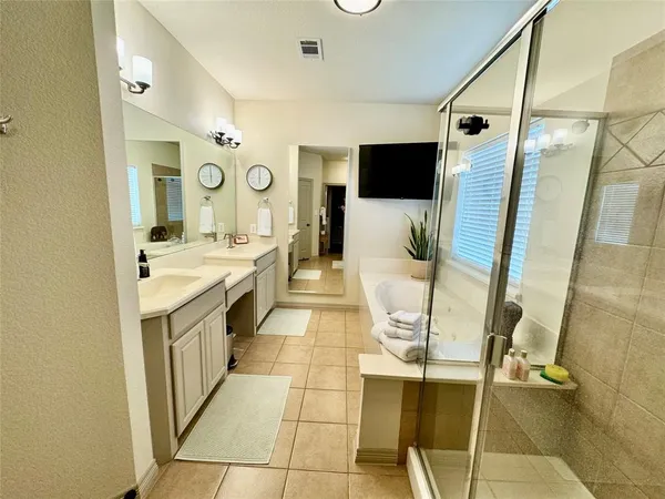 a bathroom with a double vanity sink mirror and shower
