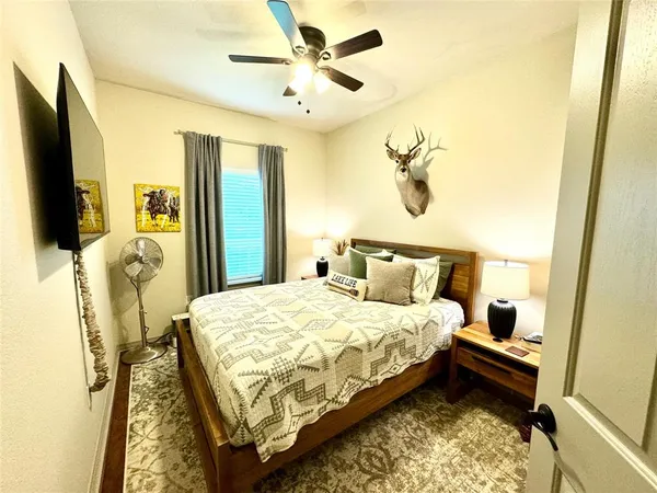 a bedroom with a bed dresser and a flat tv screen