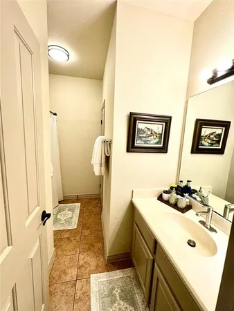 a bathroom with a sink and mirror with bathtub
