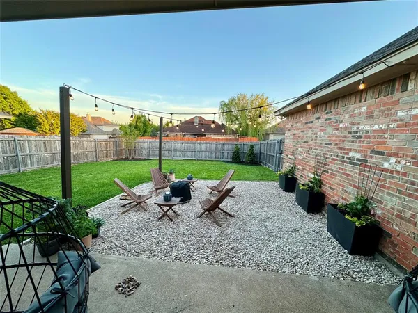 a view of a patio with a table and chairs potted plants with wooden fence