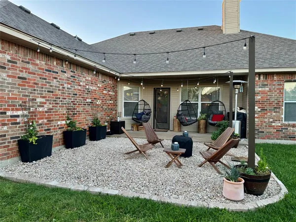 a view of a patio with table and chairs potted plants