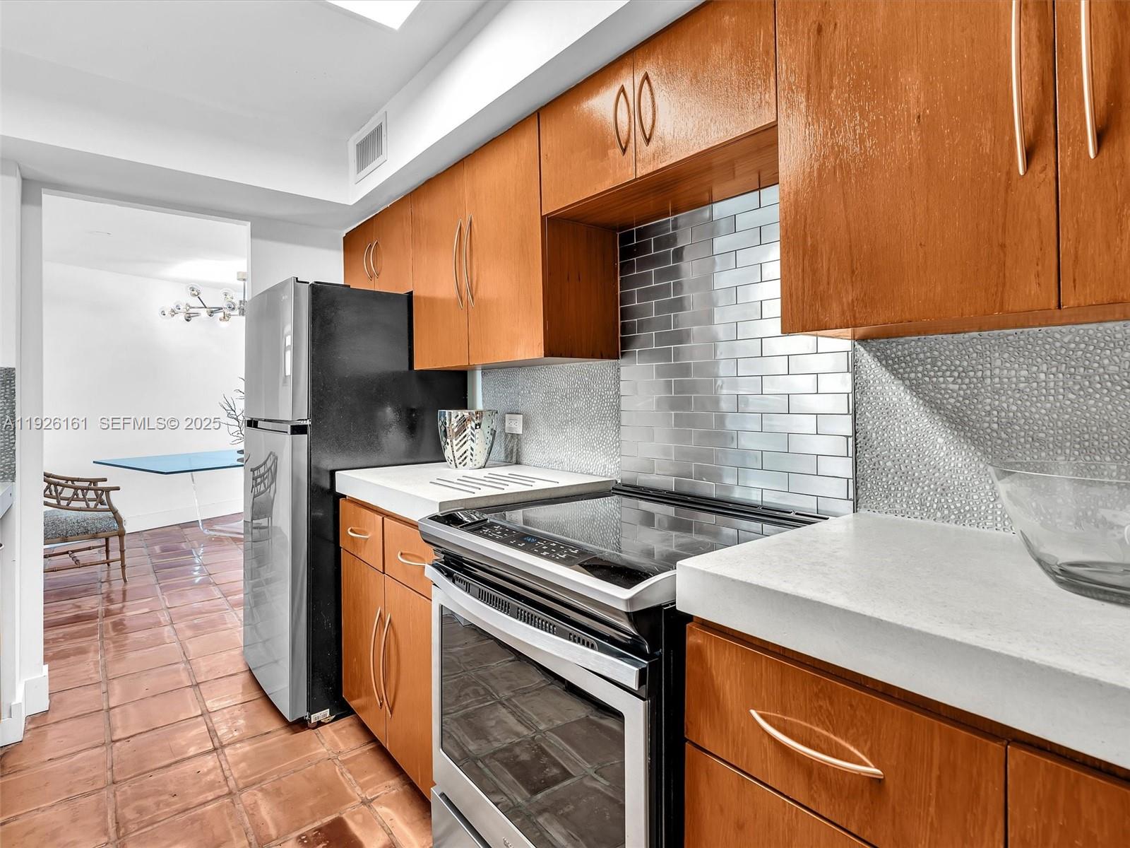 1881 Washington Avenue, Unit 16E Miami Beach, FL 33139 - Photo 14 of 65 a kitchen with stainless steel appliances granite countertop a sink stove and refrigerator