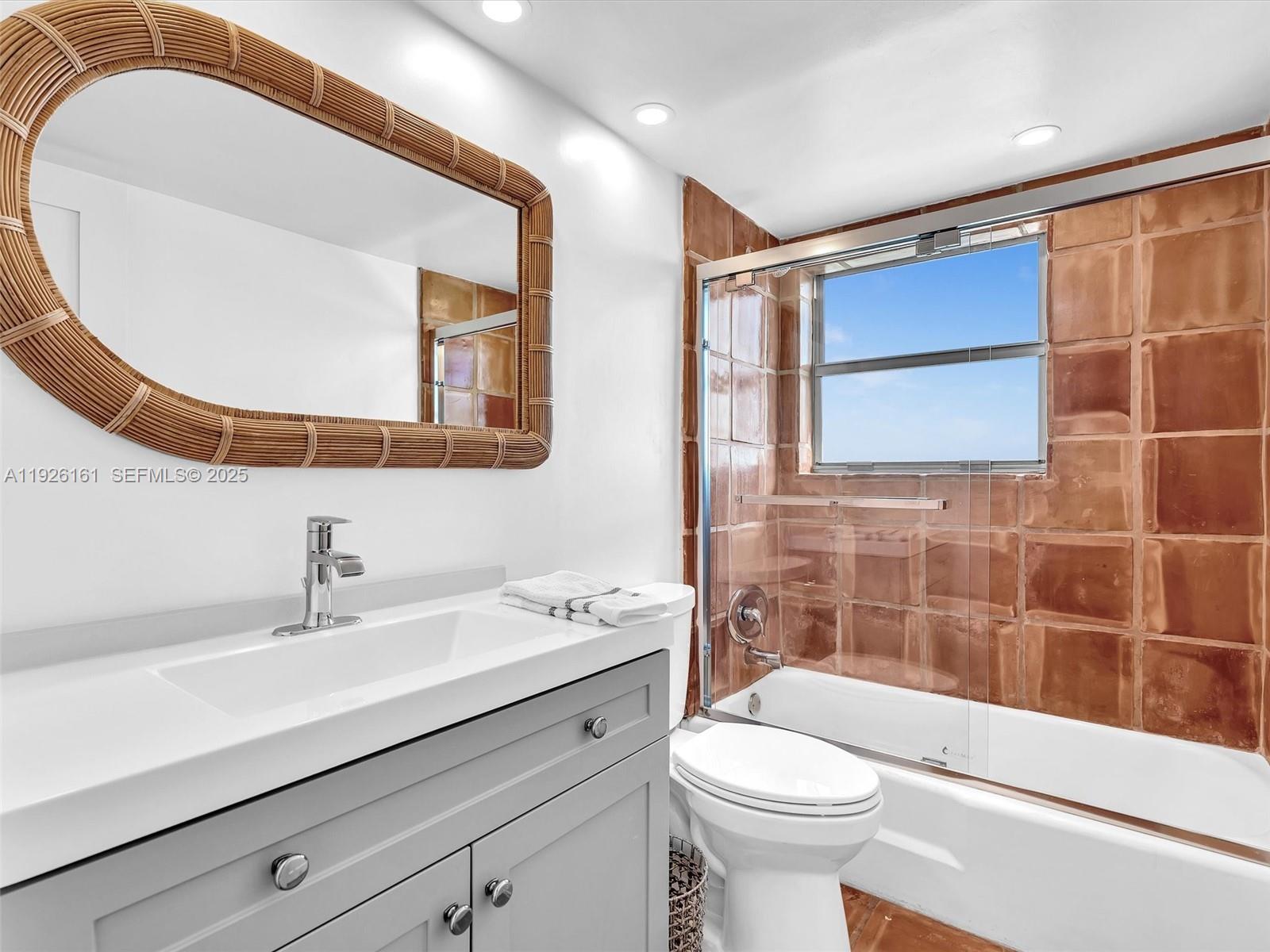 1881 Washington Avenue, Unit 16E Miami Beach, FL 33139 - Photo 33 of 65 a bathroom with a sink a toilet and a mirror