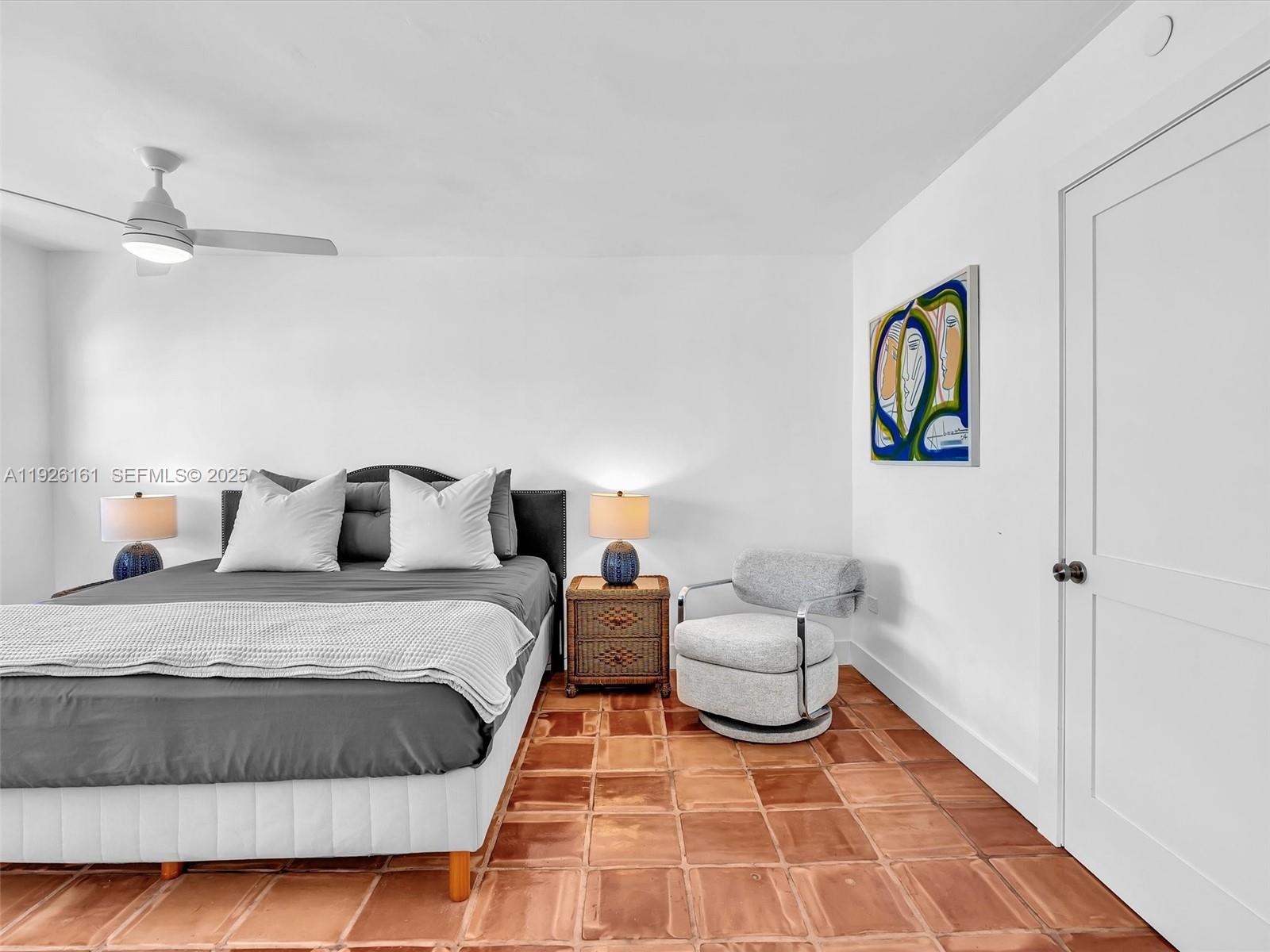 1881 Washington Avenue, Unit 16E Miami Beach, FL 33139 - Photo 34 of 65 a spacious bedroom with a bed and painting on the wall