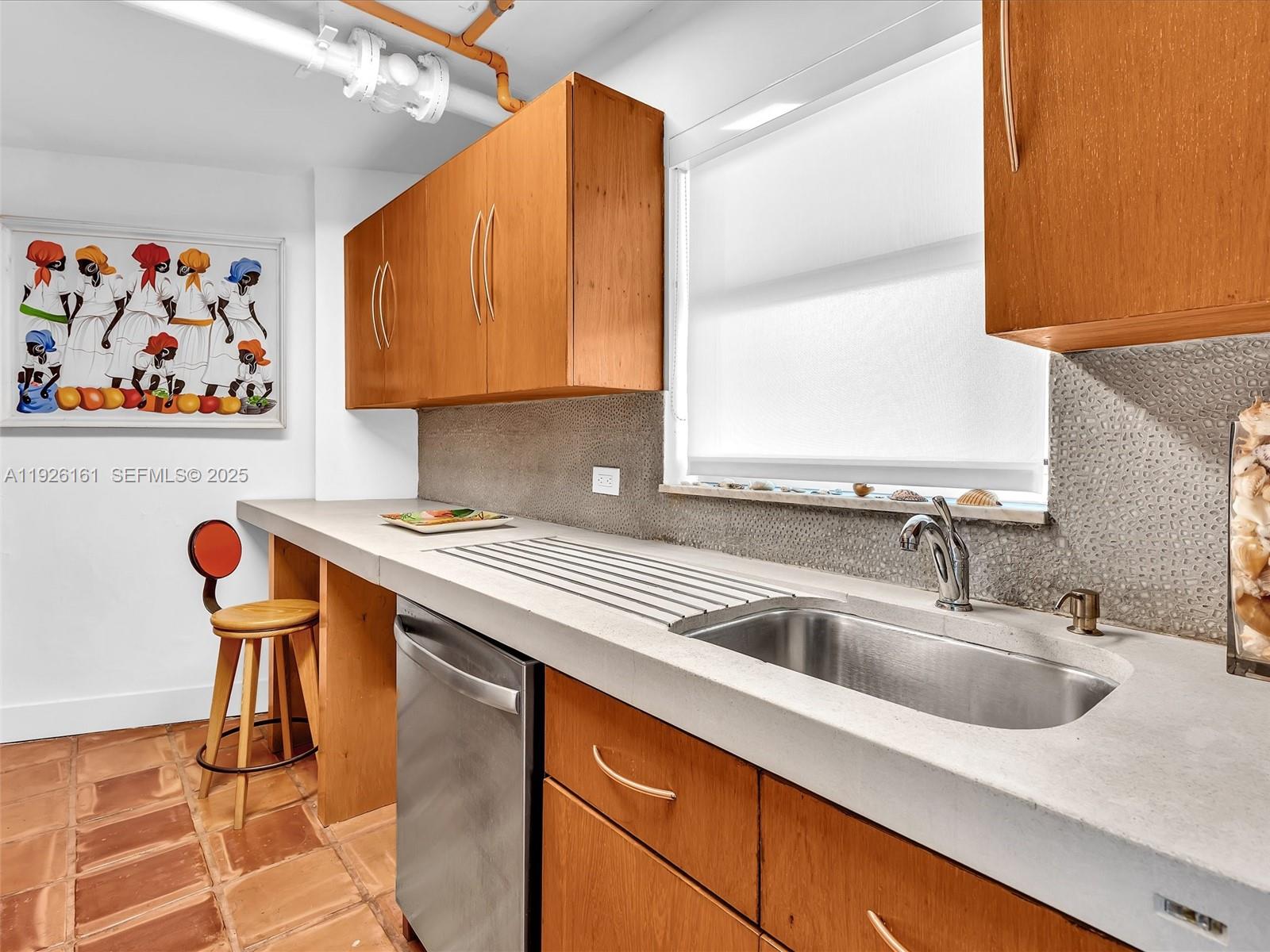 1881 Washington Avenue, Unit 16E Miami Beach, FL 33139 - Photo 8 of 65 a kitchen with stainless steel appliances a sink and a refrigerator