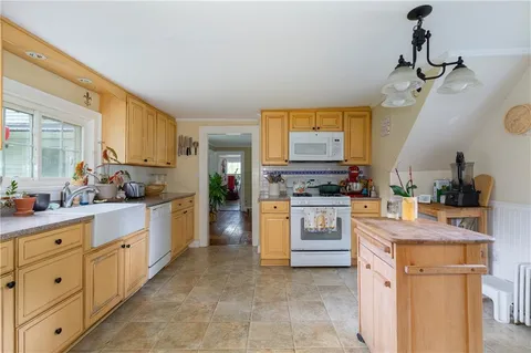 a kitchen with white cabinets and white appliances