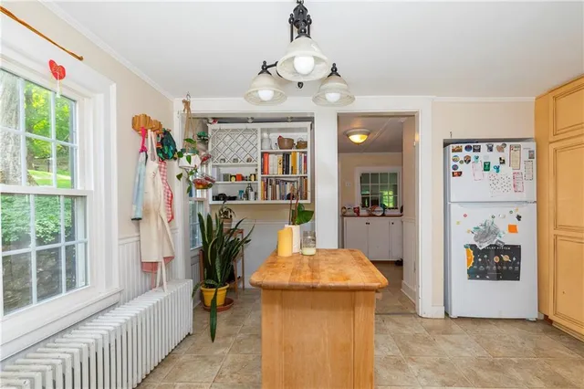 a view of a hallway with furniture and a chandelier