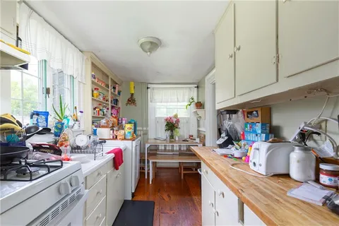 a room filled with furniture a flat screen tv and a sink