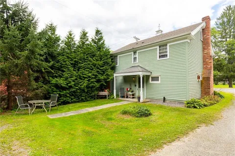 a view of a house with pool and chairs