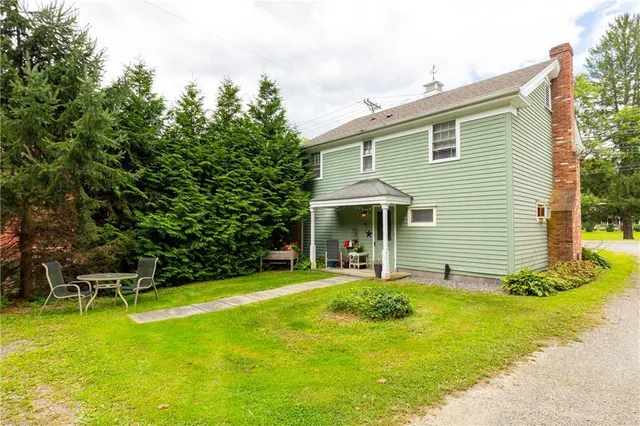 a view of a house with pool and chairs