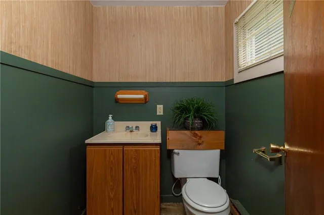 a bathroom with a toilet a sink and mirror