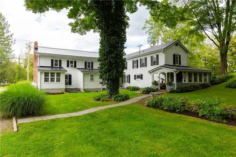 a front view of a house with a yard and trees
