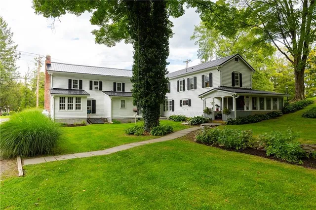 a front view of a house with a yard and trees