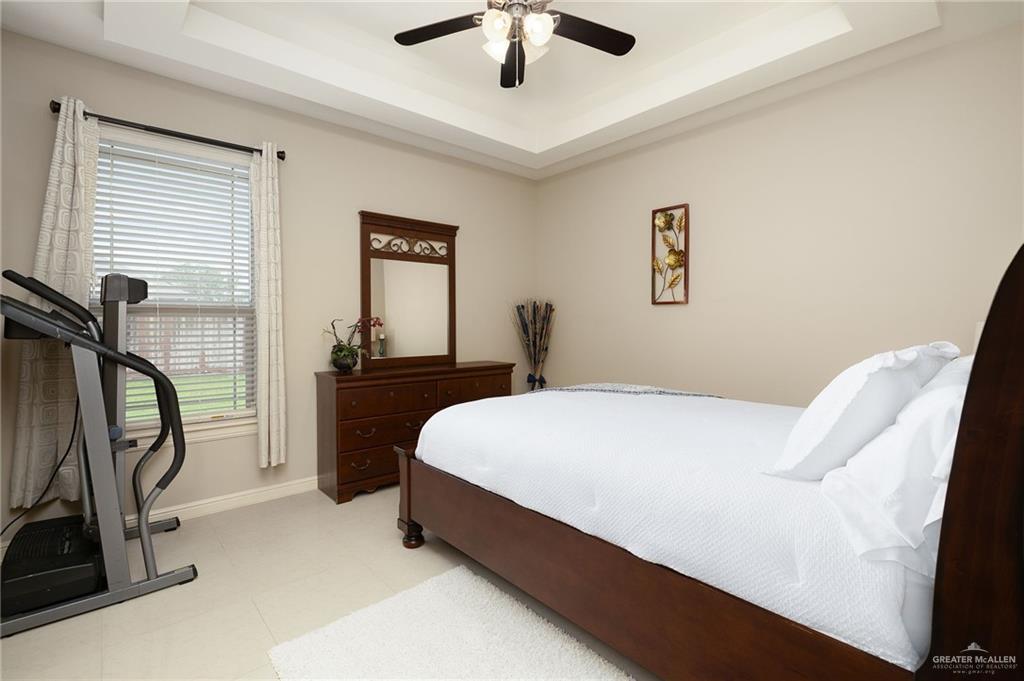 704 Santa Fe Street Weslaco, TX 78596 - Photo 16 of 25 a bedroom with a bed and a chandelier