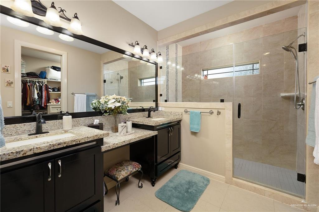 704 Santa Fe Street Weslaco, TX 78596 - Photo 20 of 25 a bathroom with a granite countertop sink a mirror and shower