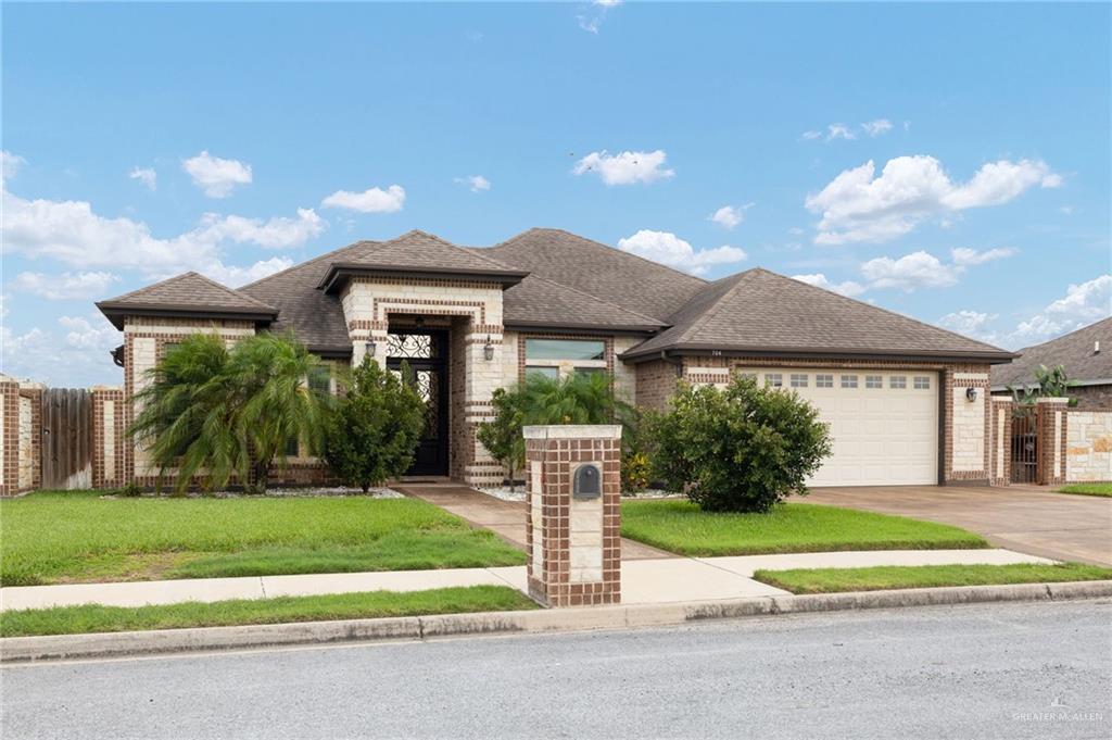 704 Santa Fe Street Weslaco, TX 78596 - Photo 3 of 25 a front view of a house with a yard and potted plants
