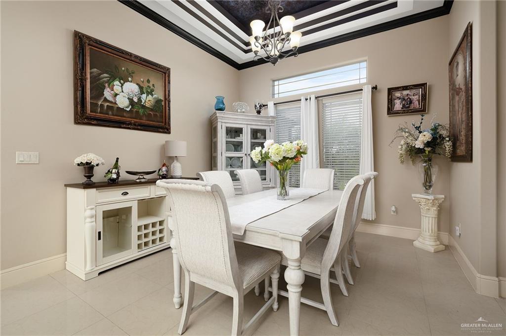 704 Santa Fe Street Weslaco, TX 78596 - Photo 7 of 25 a dining room with furniture a kitchen island a chandelier and a stove