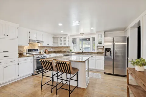 a kitchen with granite countertop a stove sink and cabinets