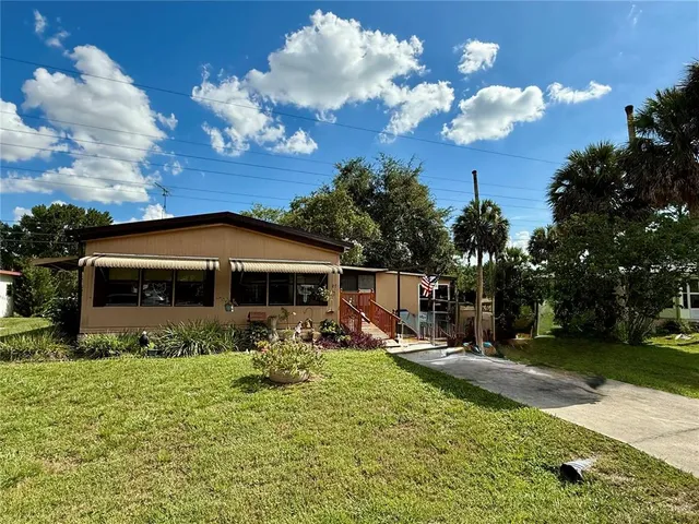 a front view of a house with garden yard and outdoor seating