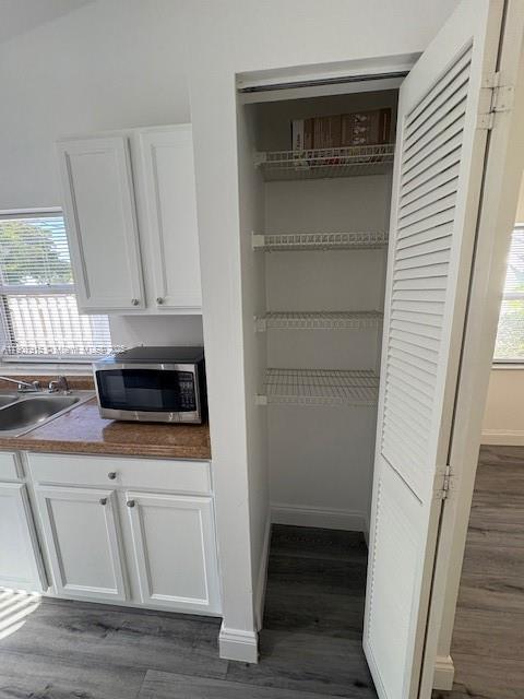 1141 Southwest 111th Way Davie, FL 33324 - Photo 8 of 19 a kitchen with white cabinets and a wooden floor