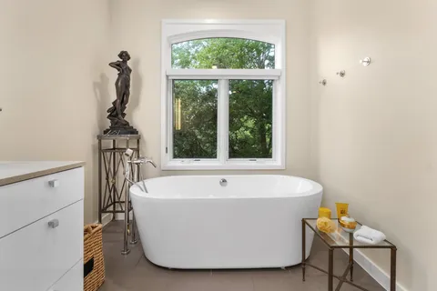 a white bath tub sitting in a bathroom next to a window