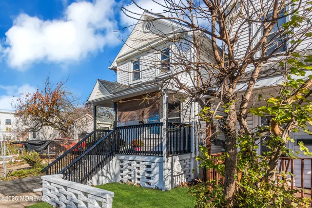 a view of a house with a small yard and wooden fence