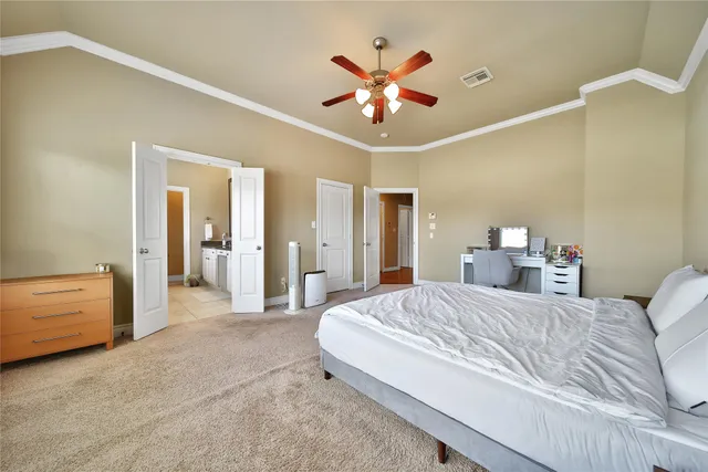 a bedroom with a large bed and a chandelier