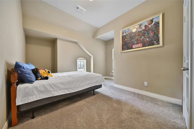a bedroom with a bed and painting on the wall