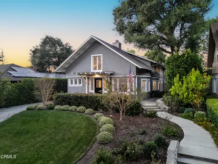 a view of a house with a big yard plants and large trees