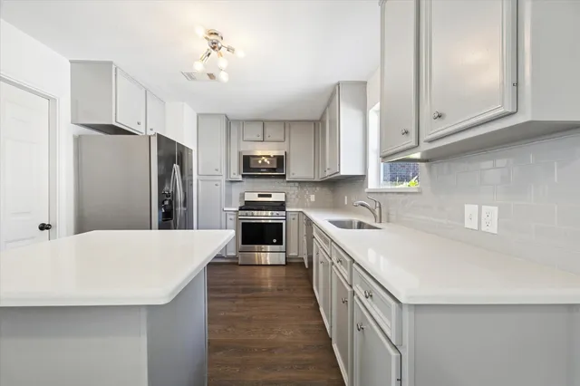 a kitchen with stainless steel appliances a refrigerator sink and cabinets