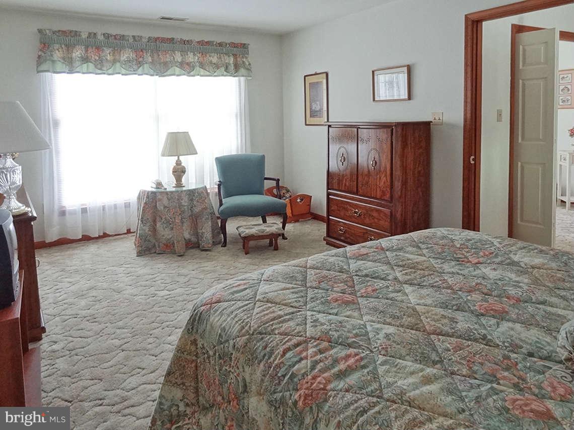 1200 Parran Road St. Leonard, MD 20685 - Photo 23 of 29 a bedroom with a bed and wooden floor