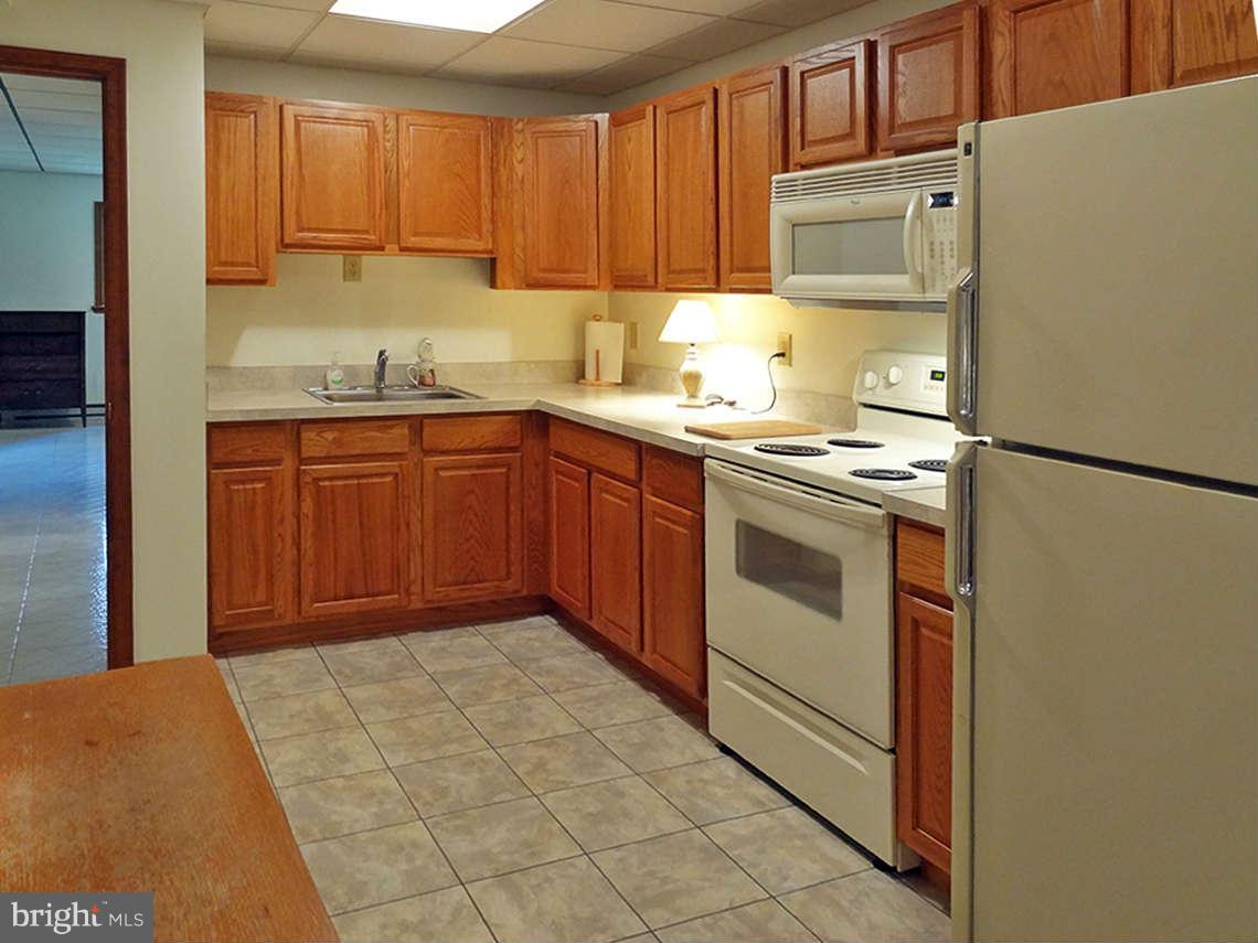 1200 Parran Road St. Leonard, MD 20685 - Photo 28 of 29 a kitchen with stainless steel appliances granite countertop a stove a sink and a refrigerator with cabinets