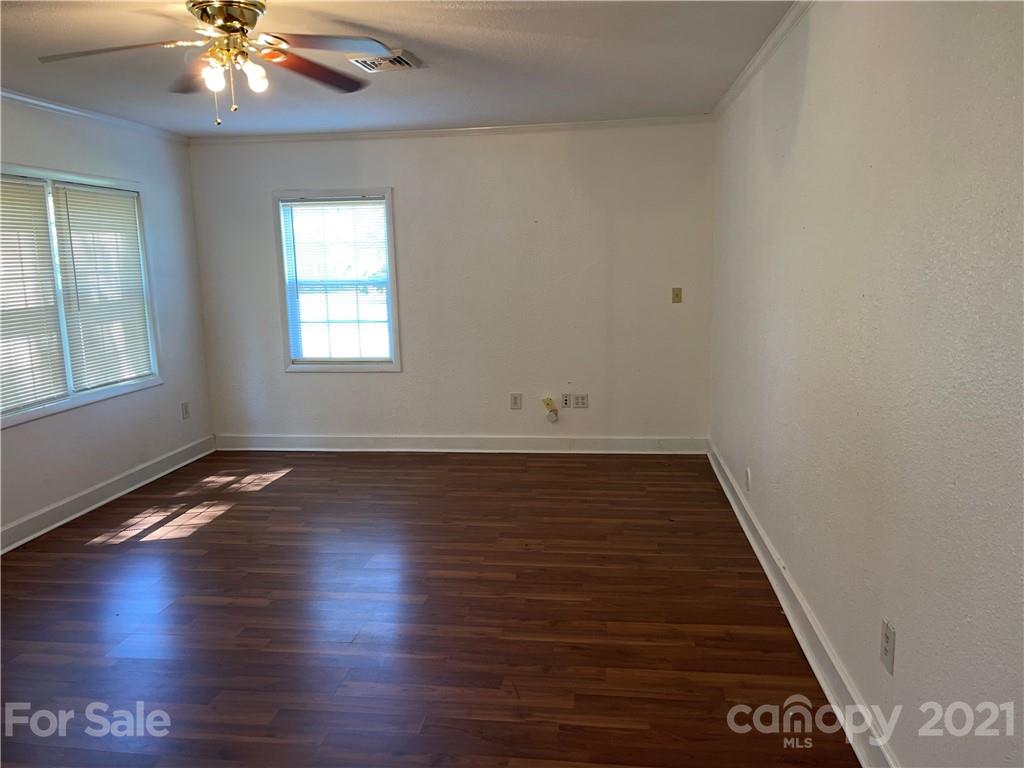 126 Sparrow Road Statesville, NC 28625 - Photo 20 of 29 an empty room with wooden floor chandelier fan and windows