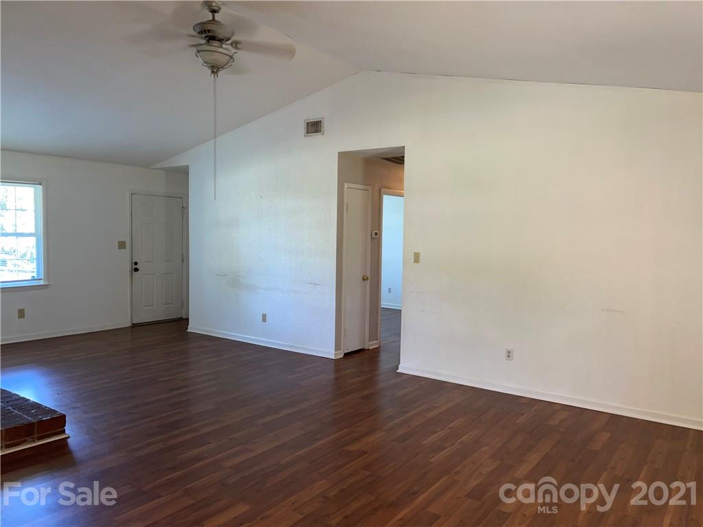 126 Sparrow Road Statesville, NC 28625 - Photo 24 of 29 an empty room with wooden floor chandelier fan and windows