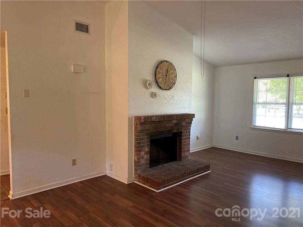 126 Sparrow Road Statesville, NC 28625 - Photo 5 of 29 a view of an empty room with wooden floor and a fireplace