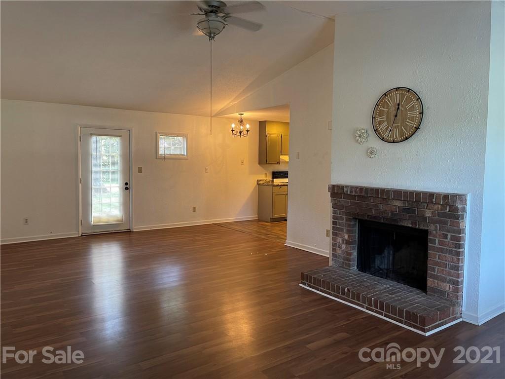 126 Sparrow Road Statesville, NC 28625 - Photo 8 of 29 an empty room with a fireplace and wooden floor