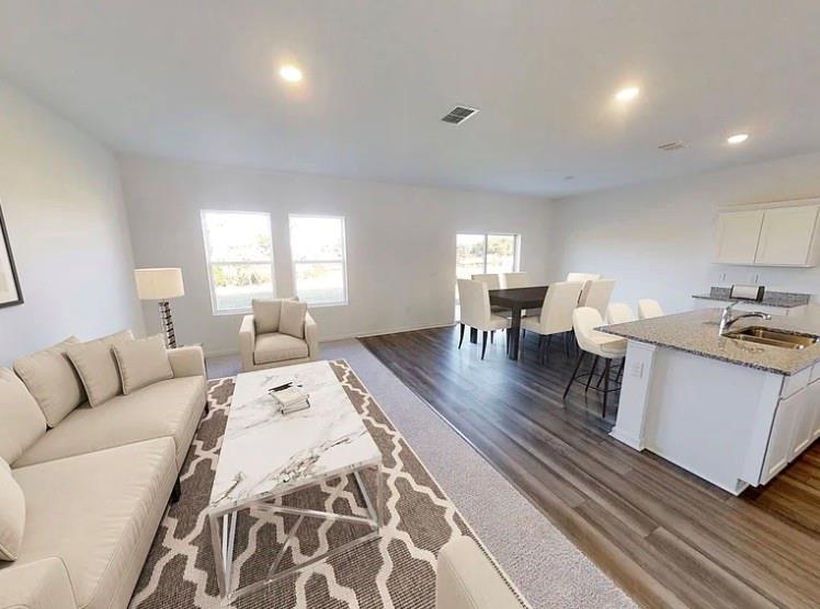 a living room with furniture and a wooden floor