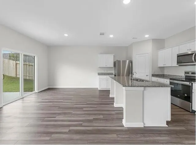 a kitchen with stainless steel appliances granite countertop a sink stove and refrigerator