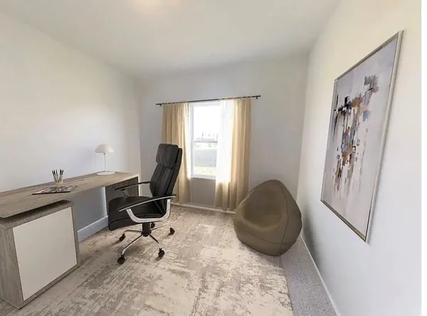 a view of a workspace with furniture and a window