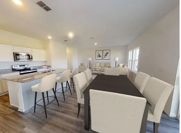 a living room with furniture a dining table and kitchen view