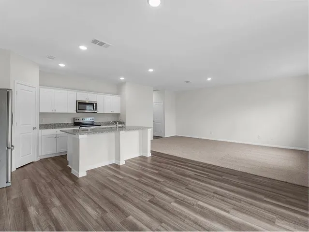 a kitchen with a refrigerator and white cabinets