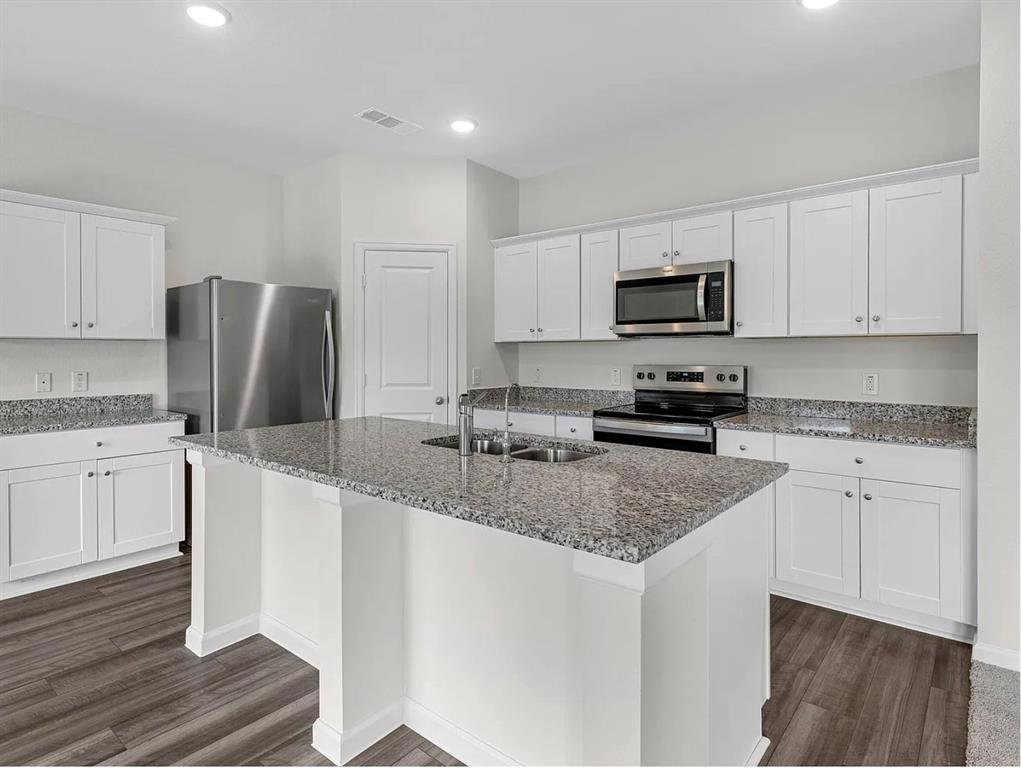 2012 Prairie Lane Melissa, TX 75454 - Photo 21 of 24 a kitchen with stainless steel appliances granite countertop a refrigerator stove microwave and sink