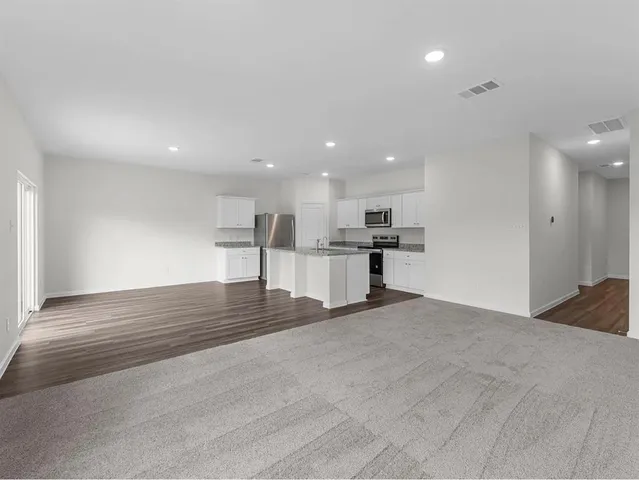 a view of kitchen with kitchen island white cabinets and refrigerator