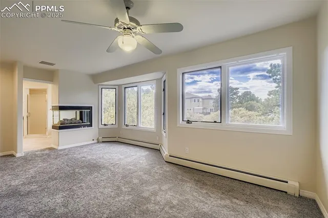 a view of empty room with a fireplace and a large window