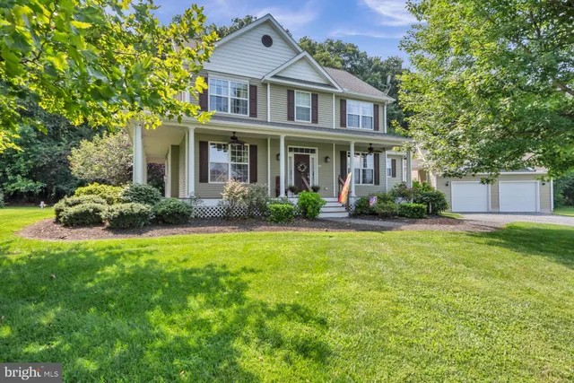 a front view of a house with a yard and trees