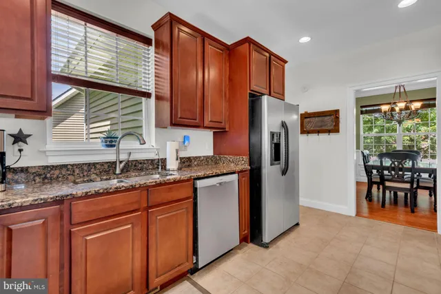 a kitchen with stainless steel appliances granite countertop a refrigerator and a sink