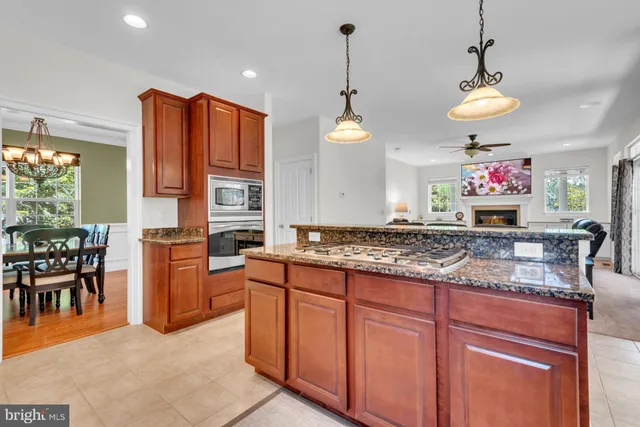 a kitchen with stainless steel appliances granite countertop a stove a refrigerator and a wooden cabinets