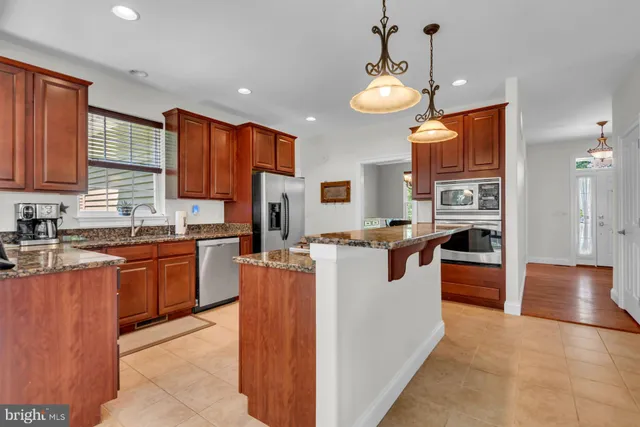 a kitchen with stainless steel appliances granite countertop a sink a stove and a refrigerator