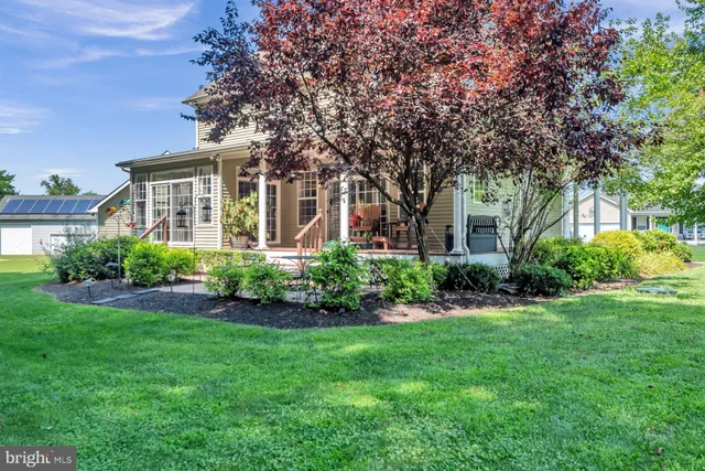 a view of a house with a big yard and large trees